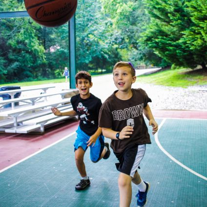 Two boys play basketball at Jewish summer camp.