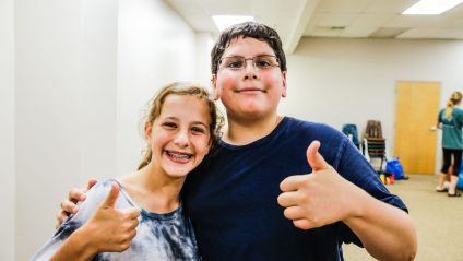 Two campers posing with thumbs up