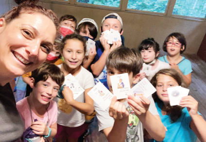 Snait zBen-Herut and campers playing a game with Hebrew cards