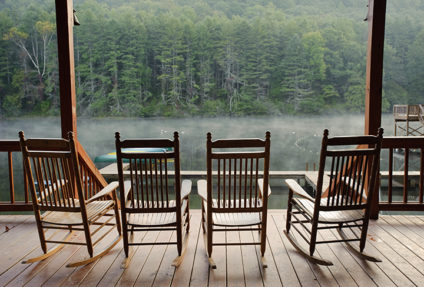 4 rocking chairs on a porch over looking the lake